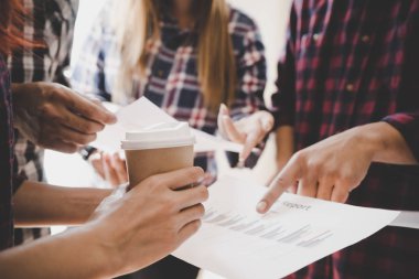 İş toplantısı için veri tablosunu gösteren eller