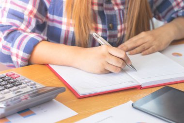 Kadın rahat yaratıcı tasarımcı işçi defter üzerinde not yazma
