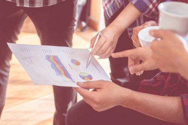 İş toplantısı için veri tablosunu gösteren eller