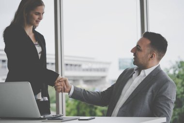 İş kadını partneriyle tokalaşıyor.