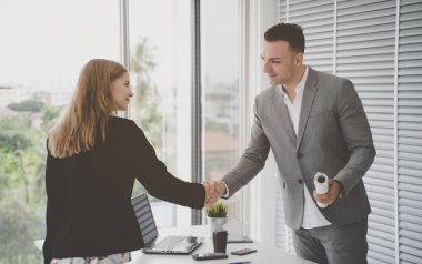 İş kadını partneriyle tokalaşıyor.