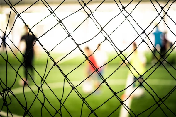 Soccer training net blur on training ground with children