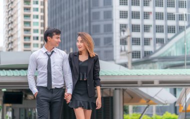 Ofis aşığı çift modern bir tren istasyonunda birlikte yürüyor.