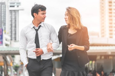 Ofis aşığı çift modern bir tren istasyonunda birlikte yürüyor.