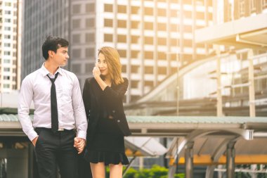 Ofis aşığı çift modern bir tren istasyonunda birlikte yürüyor.