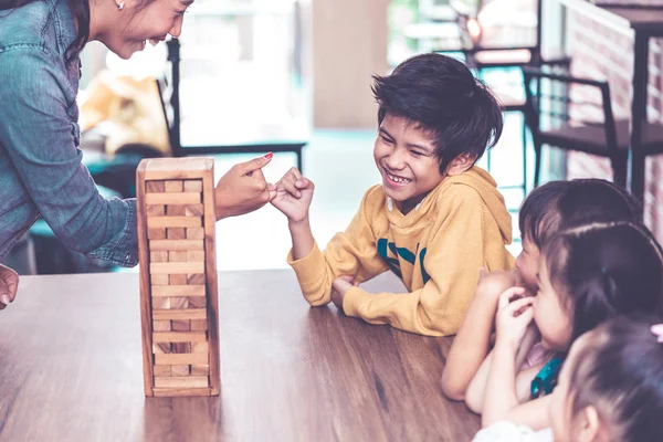 Nauczyciel Uczniowie Budują Wspólnie Wieżę Klocków Zabawek — Zdjęcie stockowe