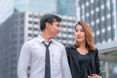 Ofis aşığı çift modern bir tren istasyonunda birlikte yürüyor.