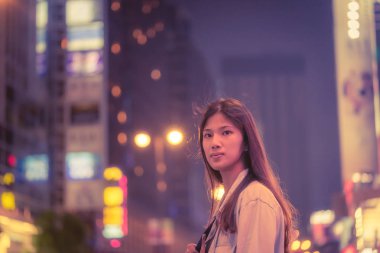 Hong Kong 'un gece sokağındaki sevimli Asyalı gezgin kız.