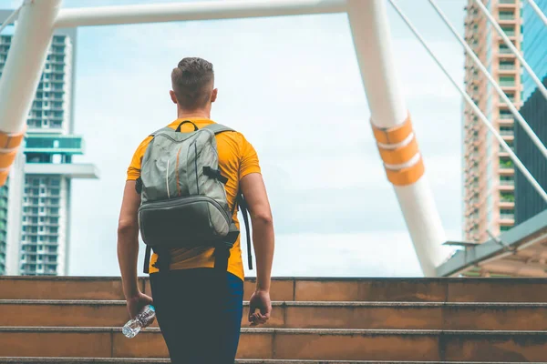 Erkek spor adamı modern şehirde merdivenden yürüyor