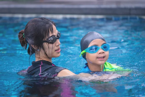 Mother is teaching her daughter to swim