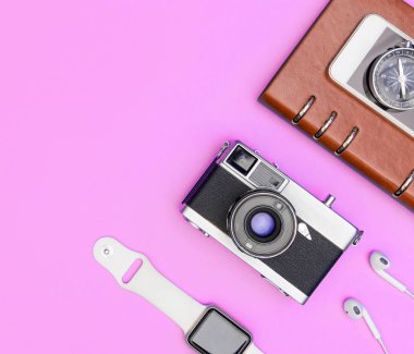 Seyahat aksesuarları nesneleri ve gadget'lar pembe pastel üzerinde üst görünüm flatlay