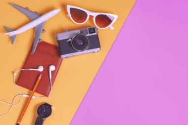 pasaport kamera ve uçak ile turuncu mor arka plan üzerinde seyahat nesneleri ve aksesuarları