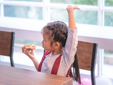 Anaokulu öğrencileri daha fazla pizza için el kaldırıyor.