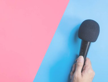 Müzik konsepti için mavi pembe arka plan üzerinde siyah mikrofon