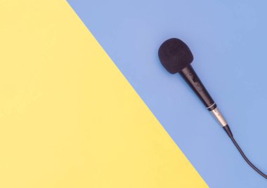 Müzik konsepti için mavi sarı arka planda siyah mikrofon