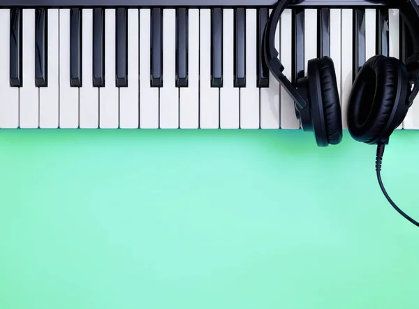 Music Keyboard and Music headphone on teal