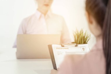 Kadın, iş görüşmesi için İnsan Kaynakları memuruna özgeçmiş veriyor.