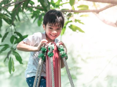 Sevimli asya çocuk oyun alanının üstünde oynuyor