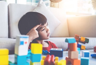 Küçük çocuk oyuncak blok oluşturma rağmen düşünme