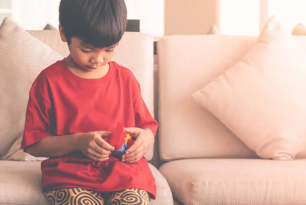 Feliz chico apilando bloques de juguete en una sala de estar para t educativa — Foto de Stock