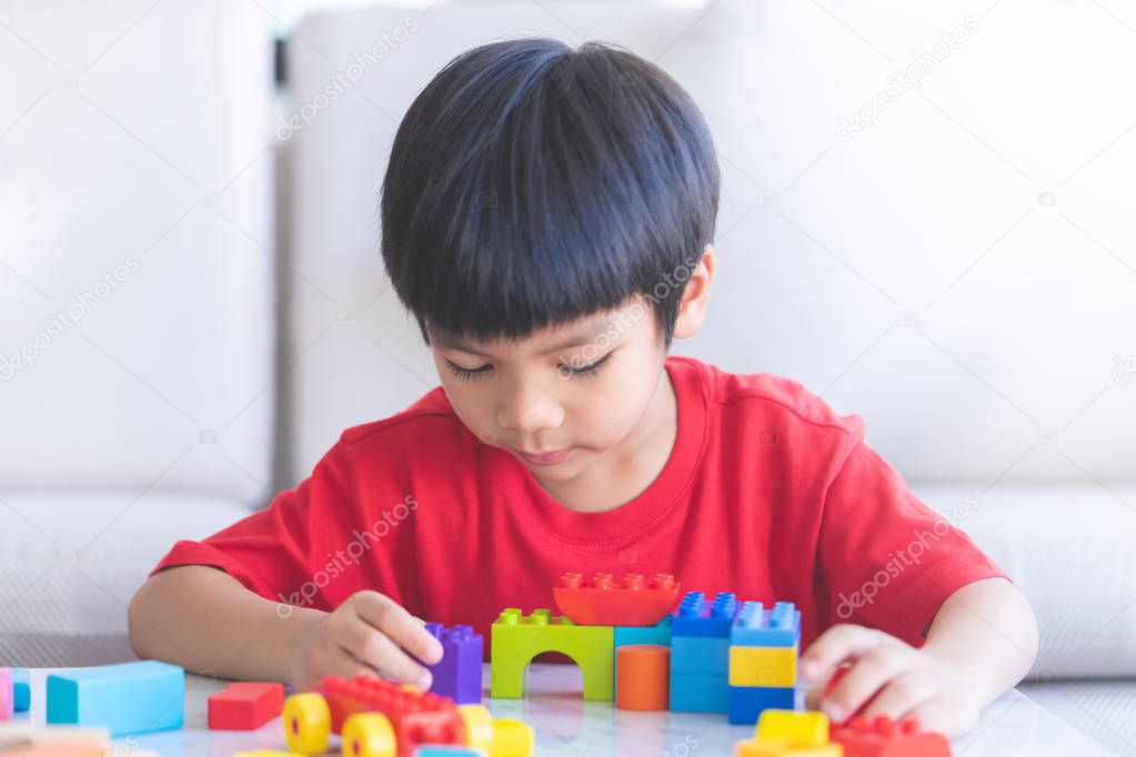 boy playing Toy blocks in living room with hand up say hi