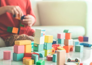 Oyuncak blokları eğitim için oturma odasına yığan mutlu çocuk.