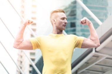 Genç spor adam modern şehirde kas uzanan