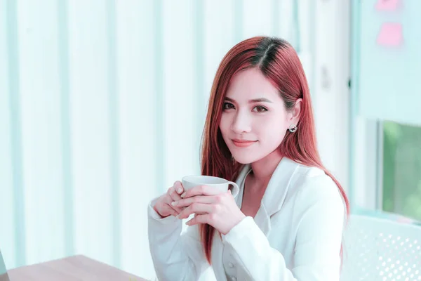 Молодая азиатка в белом берет перерыв с горячим кофе — стоковое фото