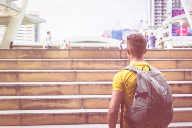 Sırt çantası ile Sporty Man gezgin modern şehirde seyahat ediyor