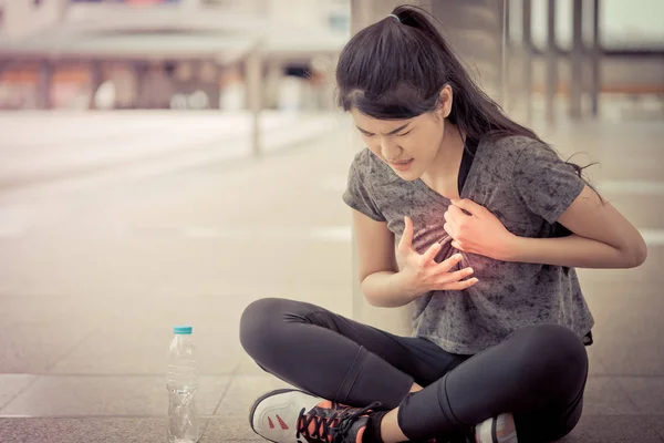Sportovní žena má poranit srdeční chorobu v srdci — Stock fotografie