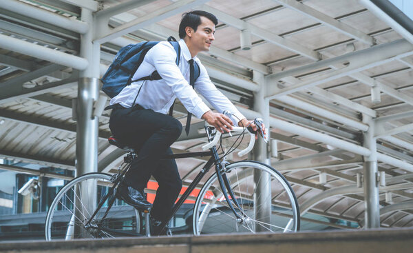 Healthy business man riding his bicycle to work in a modern city
