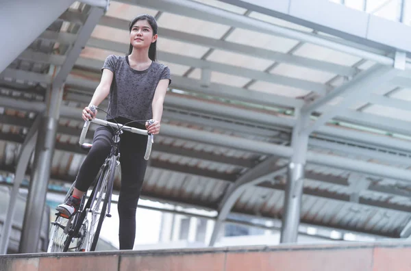 Mulher do esporte está postando com sua bicicleta na escada — Fotografia de Stock