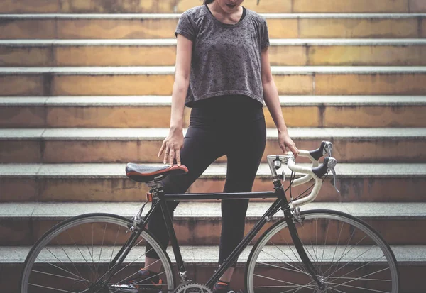 Deporte mujer está publicando con su bicicleta en la escalera — Foto de Stock
