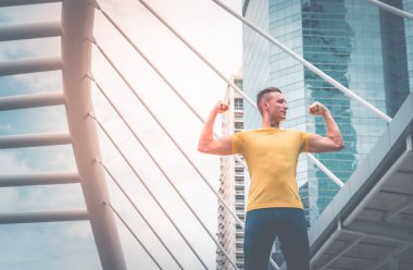 Genç spor adam modern şehirde kas uzanan
