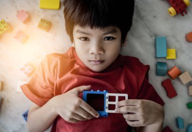 Mutlu çocuk renkli oyuncak blokları ile çevrili üst görünümü açık pencere