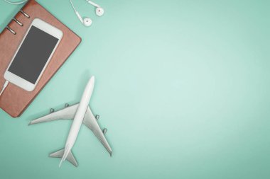 Seyahat co için mavi teal arka plan üzerinde cep telefonu ve oyuncak uçak