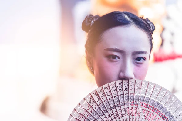 Vooraanzicht van een Chinese vrouw met houten ventilator in de tempel — Stockfoto