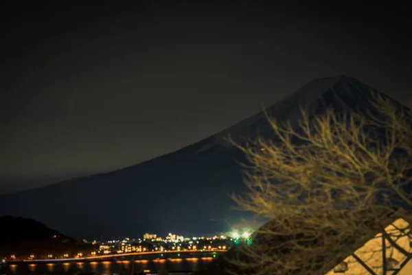 Mt. Fuji na jeziorze Kawaguchi w nocy ze światłem miejskim — Zdjęcie stockowe