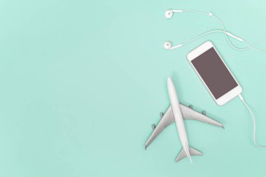 Seyahat co için mavi teal arka plan üzerinde cep telefonu ve oyuncak uçak
