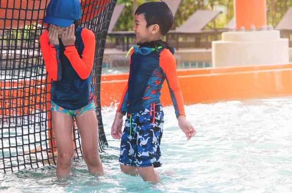 Två asiatiska syskon i att leka tillsammans i Water Aqua park pool. — Stockfoto