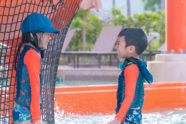 Asyalı kardeşler koşuyor ve aqua parkta kovalıyor