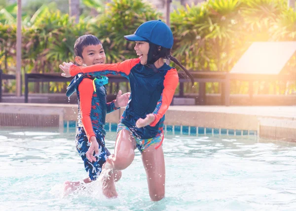 Asiático hermanos está corriendo y persiguiendo en piscina — Foto de Stock