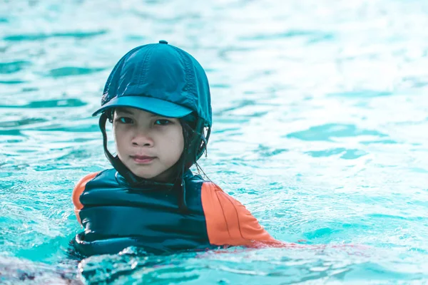 Niña está muy cansada en piscina de entrenamiento de natación —  Fotos de Stock