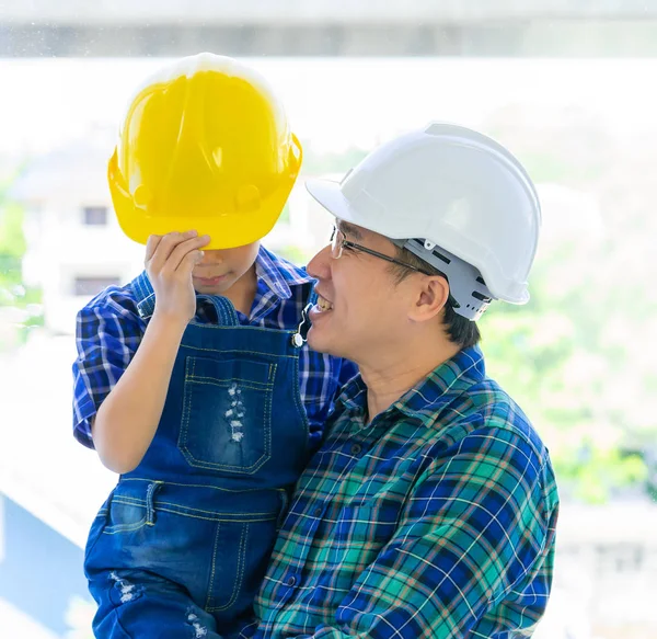 Builder Father holding his son with engineering protecting hat f