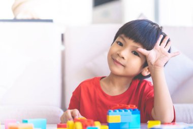el ile oturma odasında Oyuncak blokları oynayan çocuk merhaba demek