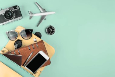 Mavi teal üzerinde bir çanta çıkan kadın seyahat ekipmanları nesne