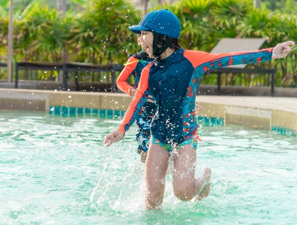 Asiático hermanos está corriendo y persiguiendo en piscina — Foto de Stock