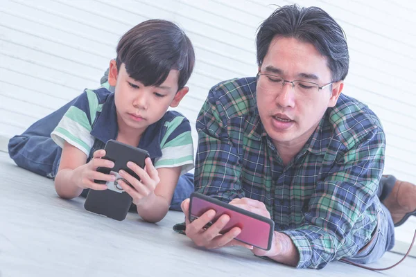 Padre asiático está enseñando a su hijo a usar el teléfono inteligente e inter — Foto de Stock