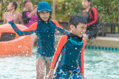 Asyalı kardeşler koşu ve Yüzme havuzunda kovalayan
