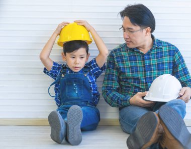 İnşaatçı baba aile bağlantısı için oğlunun yanında oturuyor. 